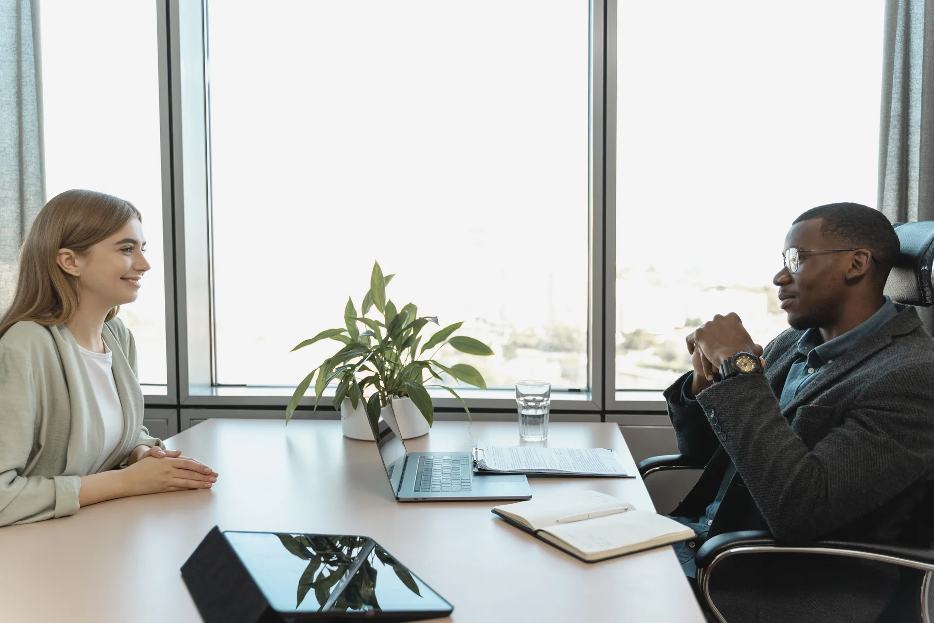 Un candidat en entretien d'embauche face à une recruteuse dans un bureau lumineux